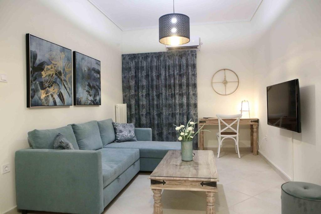 sala de estar con sofá azul y mesa en Best House, Anakreontos, Perivolaki, Nikaia, P..., en Pireo