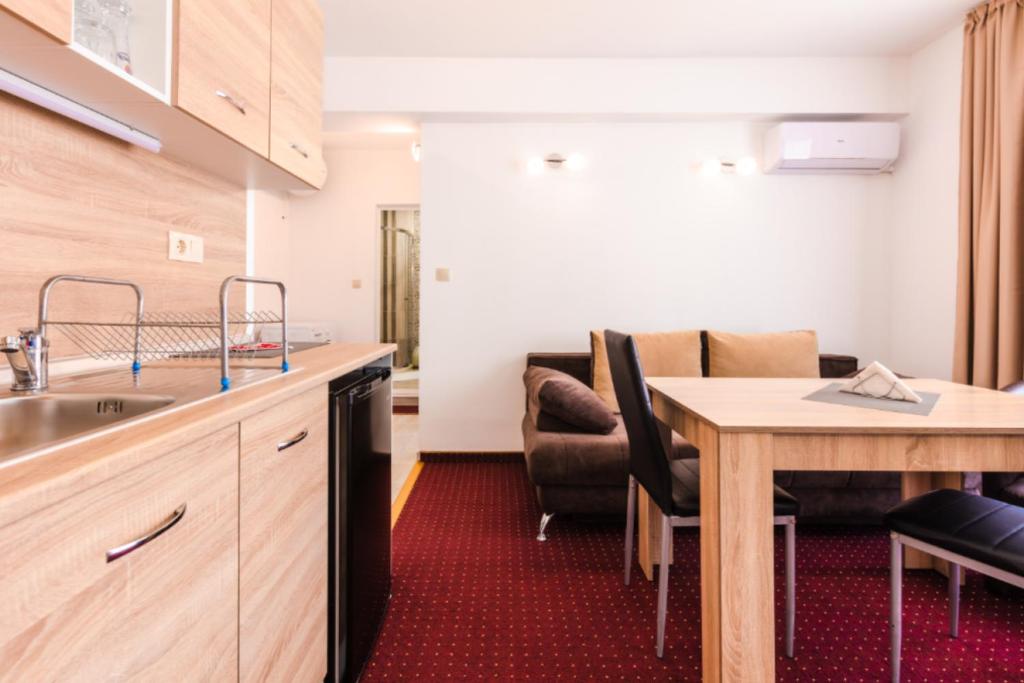 a kitchen with a sink and a table in a room at Guest House Theona in Obzor