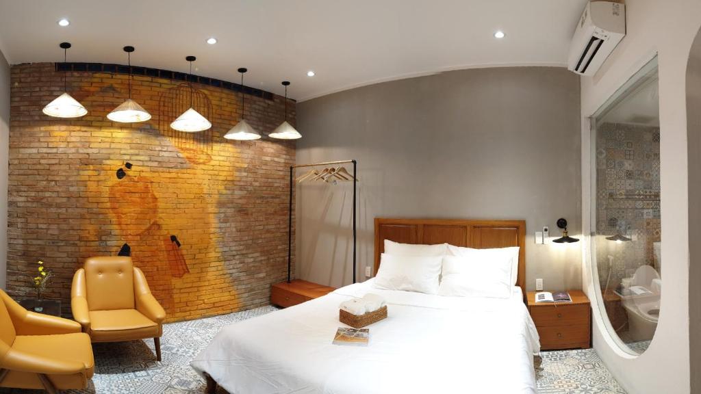 a bedroom with a bed and a brick wall at Saigon1984 Vintage Private Home Central District 1 with 6 bedrooms and 6 bathrooms in Ho Chi Minh City