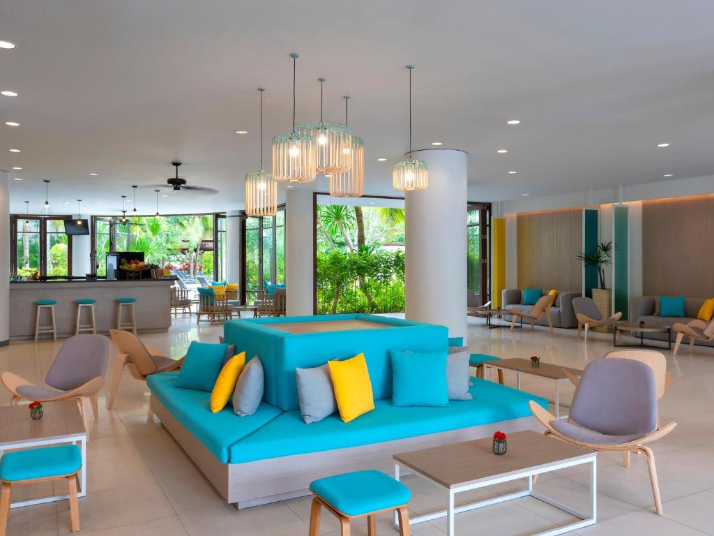 a living room with a blue couch and chairs at Ibis Phuket Patong in Patong Beach