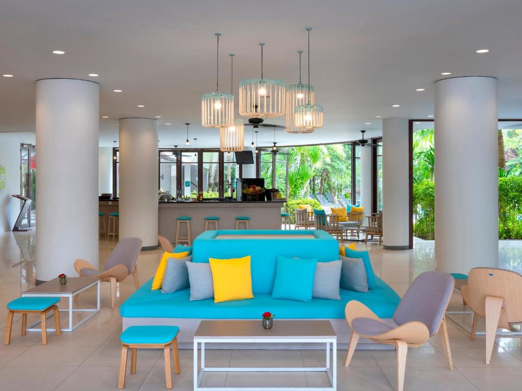a living room with a blue couch and chairs at Ibis Phuket Patong in Patong Beach