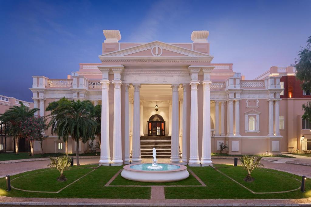 a large building with a fountain in front of it at Welcomhotel by ITC Hotels, Raja Sansi, Amritsar in Amritsar