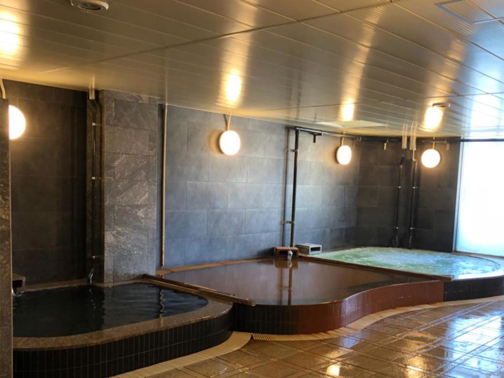 a room with a pool in the middle of a room at Kawaramachi Gion Onsen Golden Time Takamatsu (Male Only) in Takamatsu