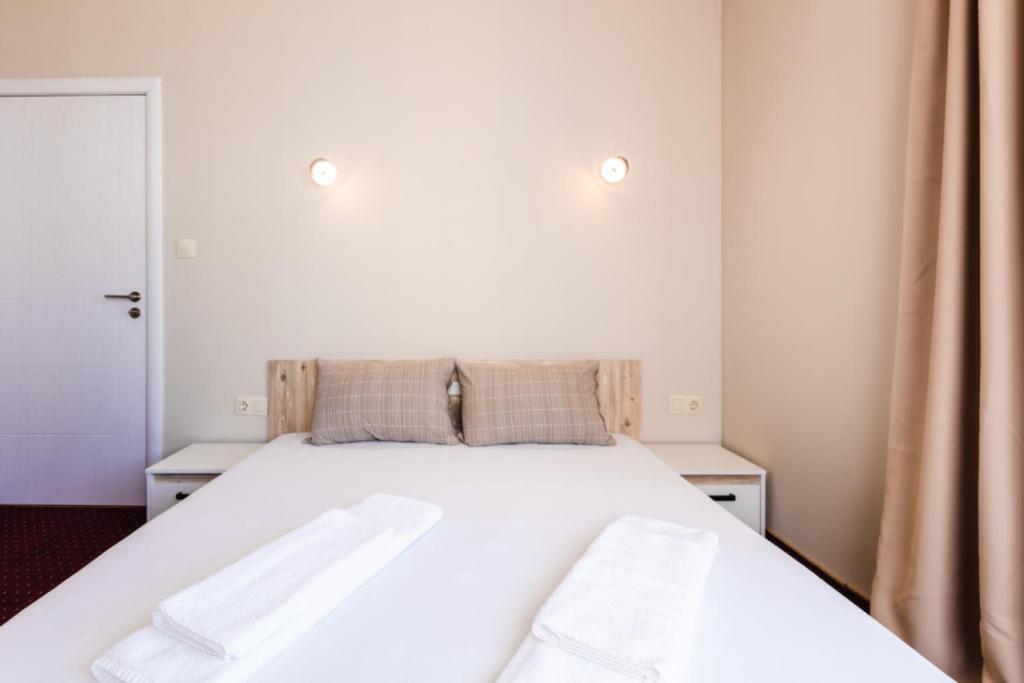 a bedroom with a white bed with two towels on it at Guest House Theona in Obzor