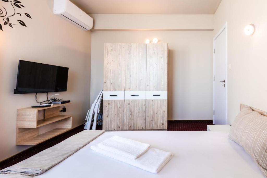 a bedroom with a bed and a tv and a cabinet at Guest House Theona in Obzor