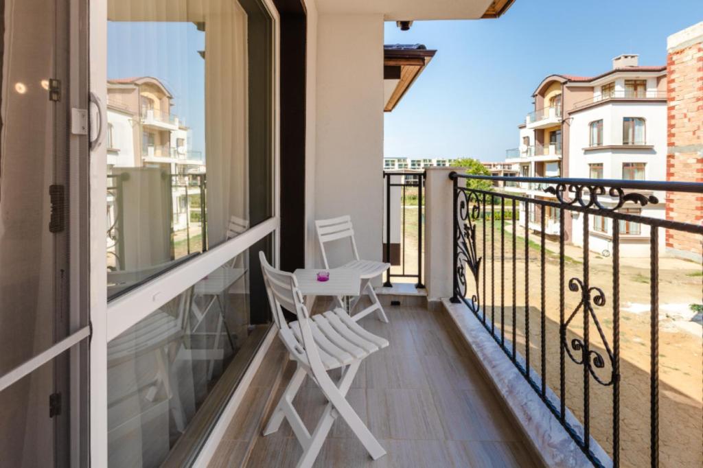 a balcony with two white chairs on a balcony at Guest House Theona in Obzor