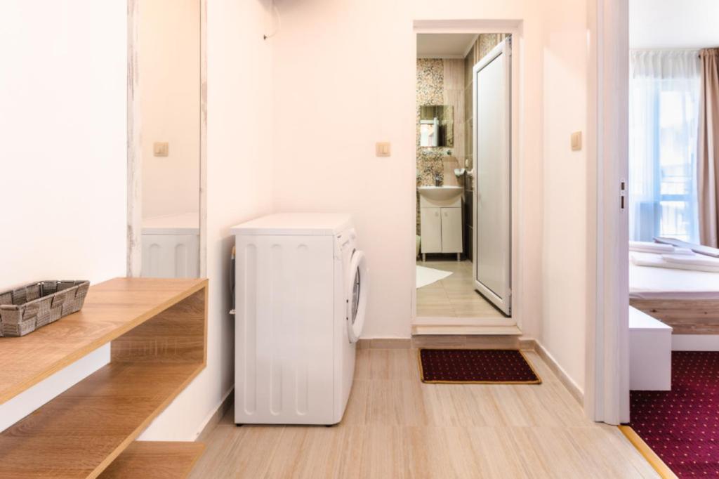 a small white refrigerator in a room with a bathroom at Guest House Theona in Obzor
