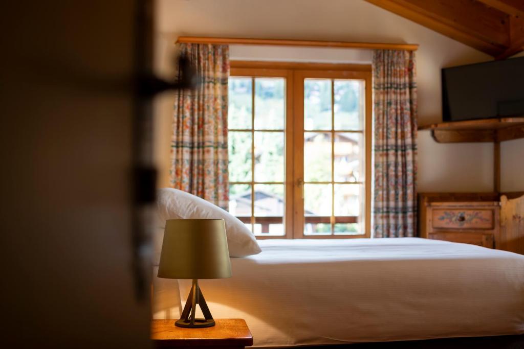 a bedroom with a bed and a window at Hotel Montpelier in Verbier