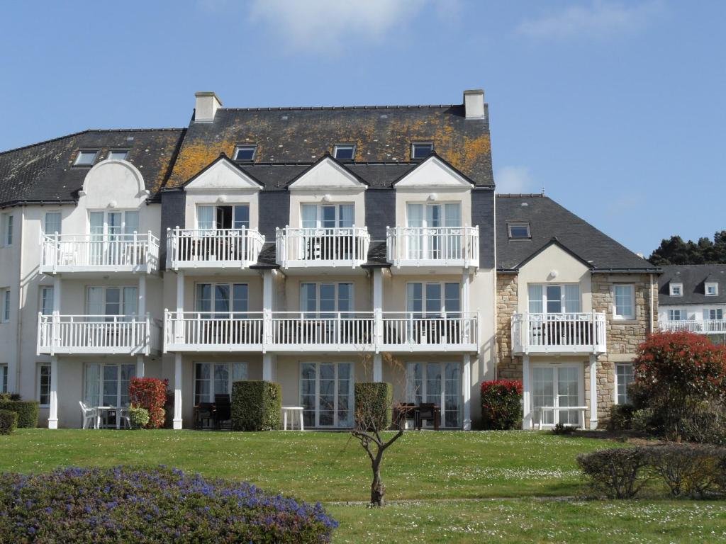 un grand bâtiment blanc avec balcon et cour dans l'établissement REF 060 Appartement pour quatre personnes résidence avec piscine vue Port Crouesty ARZON, à Arzon