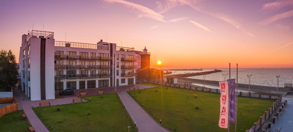 budynek nad oceanem o zachodzie słońca w obiekcie Apartamenty Przy Latarni Kropla Bałtyku w Darłówku