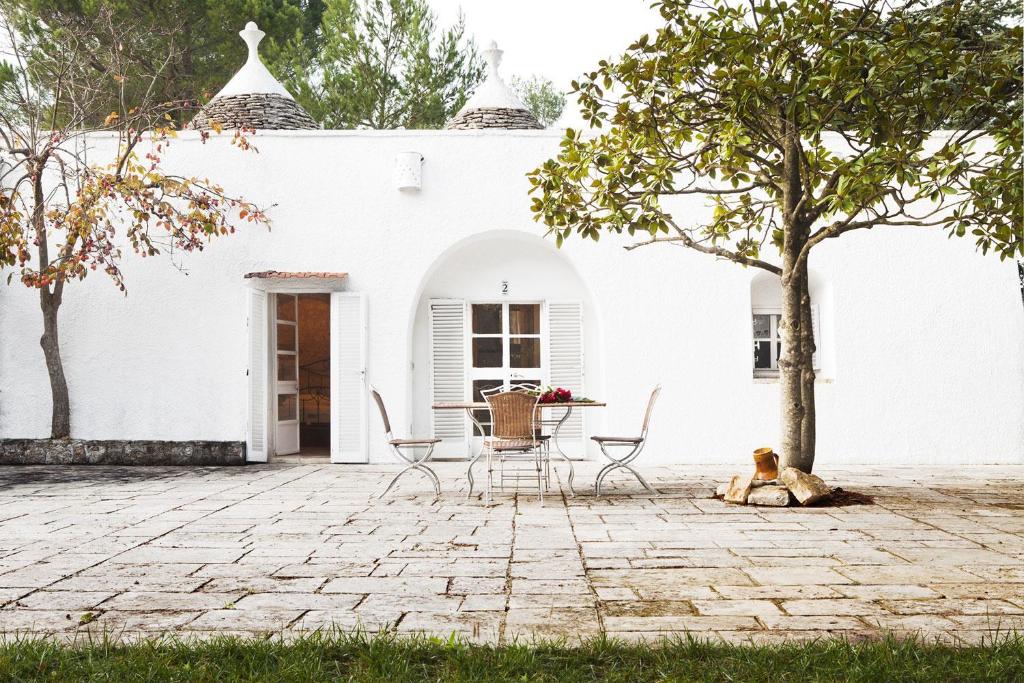 a dog laying on the ground in front of a white house at Trulli del Carmine in Martina Franca