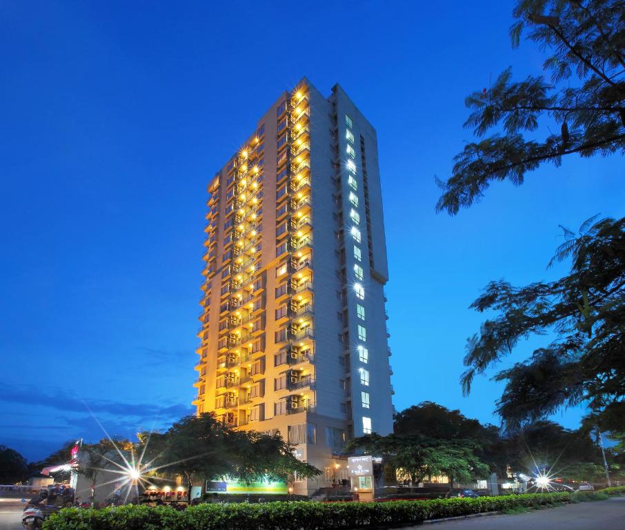 un edificio alto con luces encendidas por la noche en Starlit Suites Bangalore, en Bangalore