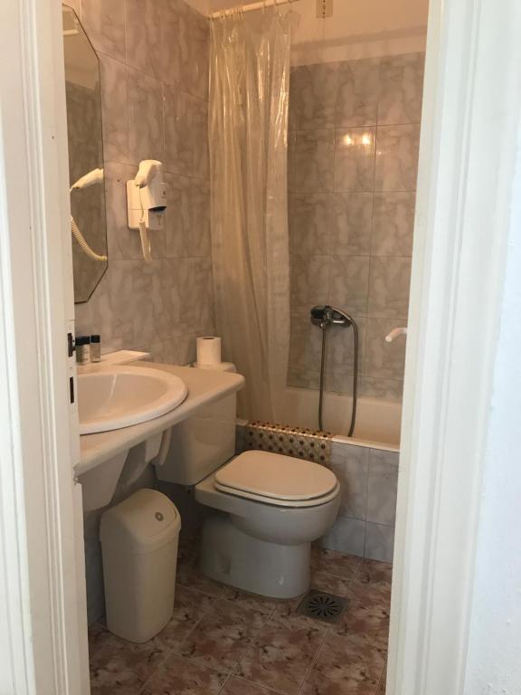 a bathroom with a toilet and a sink and a tub at Romantika in Platis Gialos