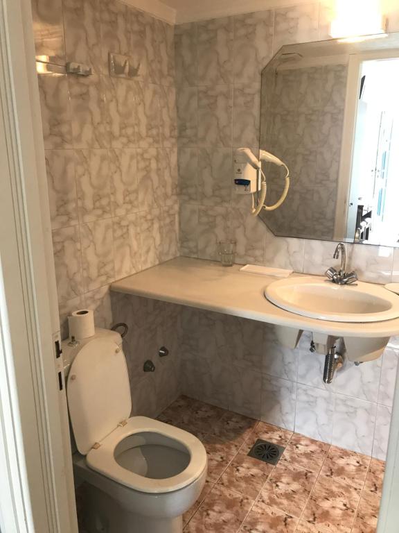 a bathroom with a toilet and a sink at Romantika in Platis Gialos