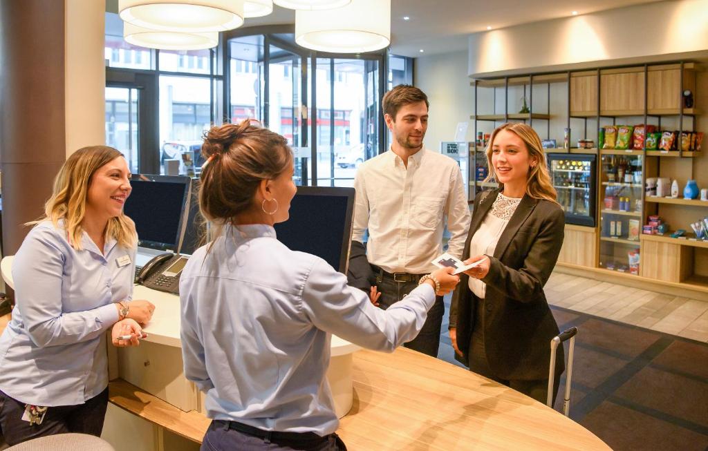 a group of people standing around a table in an office at Aparthotel Adagio Muenchen City in Munich