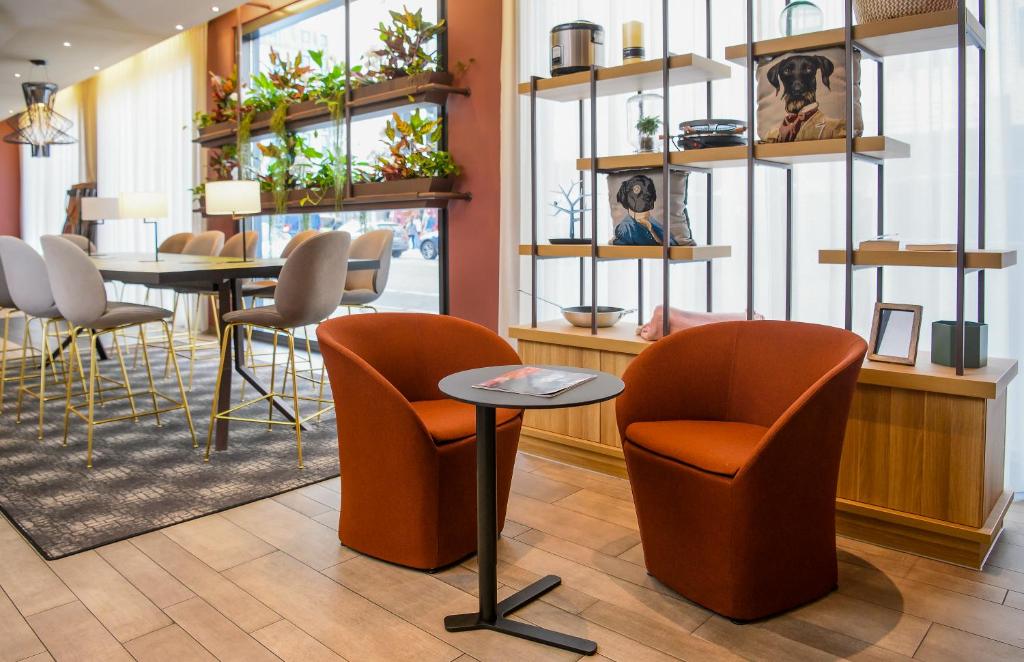 a waiting room with chairs and a table at Aparthotel Adagio Muenchen City in Munich