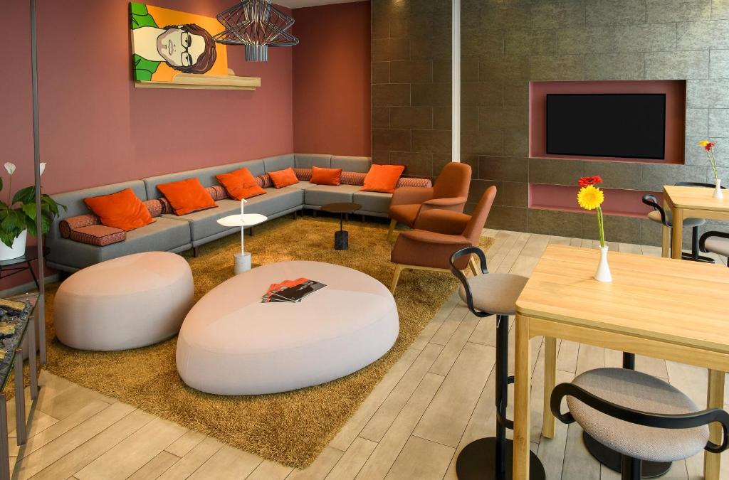 a living room with a couch and a table at Aparthotel Adagio Muenchen City in Munich