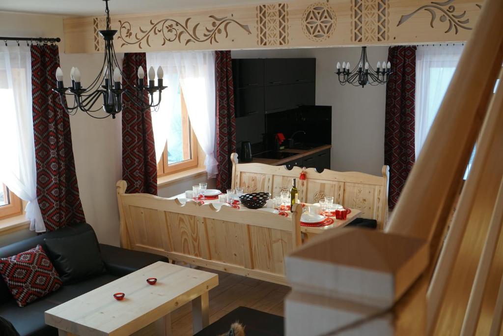 a living room with a table and a kitchen at Domek u Matusa in Biały Dunajec