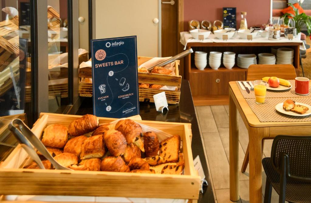 a tray of bread and pastries on a table at Aparthotel Adagio Muenchen City in Munich