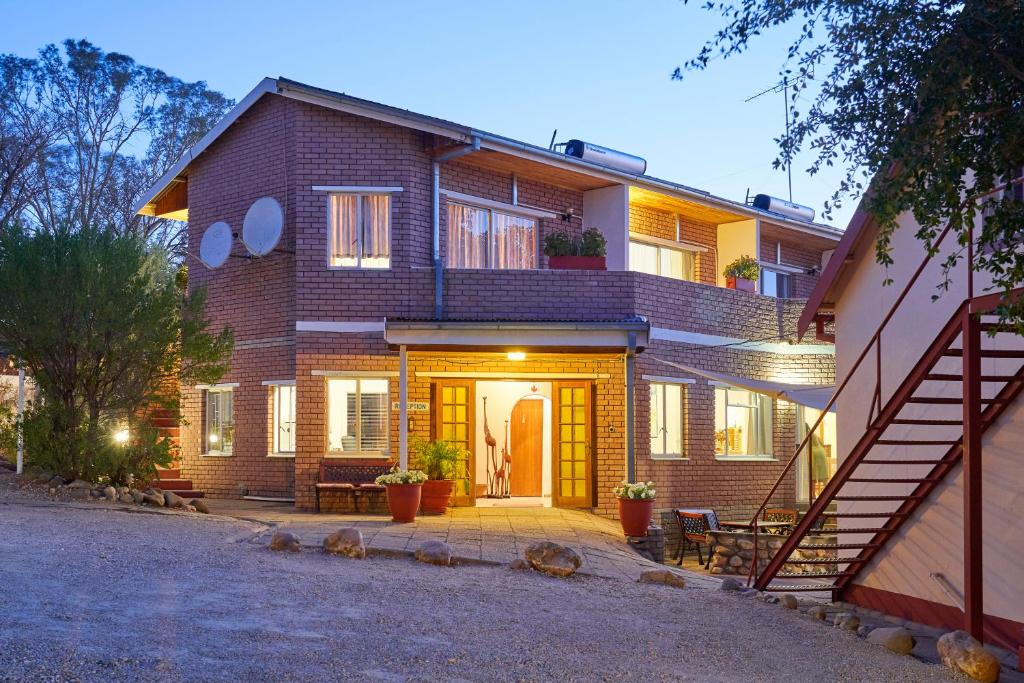 a brick house with a front door and a staircase at Hotel Uhland in Windhoek