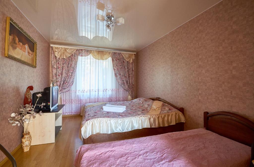 カームヤネツィ・ポジーリシクィイにあるDomashniyのベッドルーム1室(ベッド2台、テレビ、窓付)