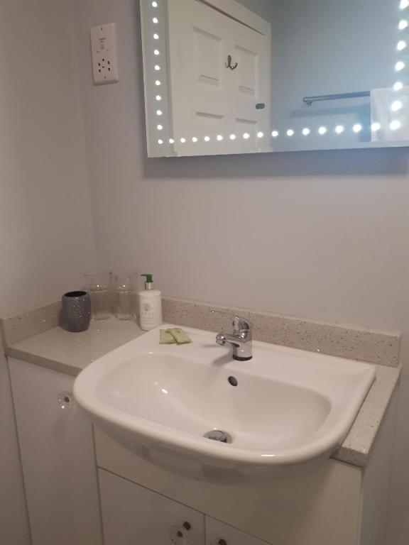 a bathroom with a white sink and a mirror at Berry House Bed & Breakfast in Littlehampton