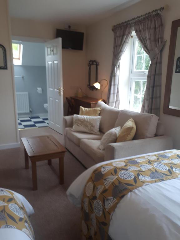 a living room with a bed and a couch at Berry House Bed & Breakfast in Littlehampton