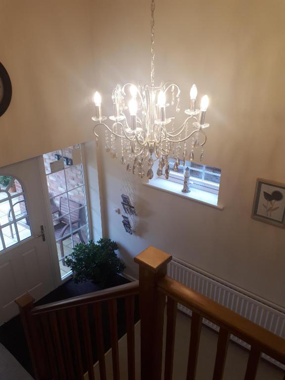 a chandelier hanging from the ceiling in a staircase at Berry House Bed & Breakfast in Littlehampton