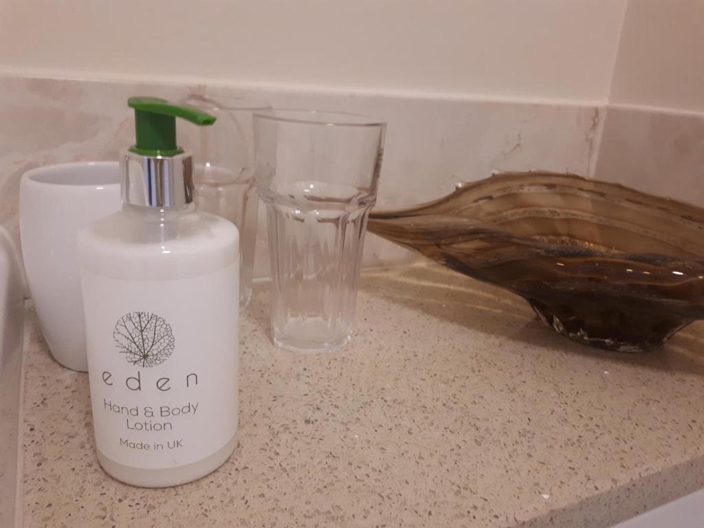 a bottle of cleaner sitting on a counter next to a glass at Berry House Bed & Breakfast in Littlehampton