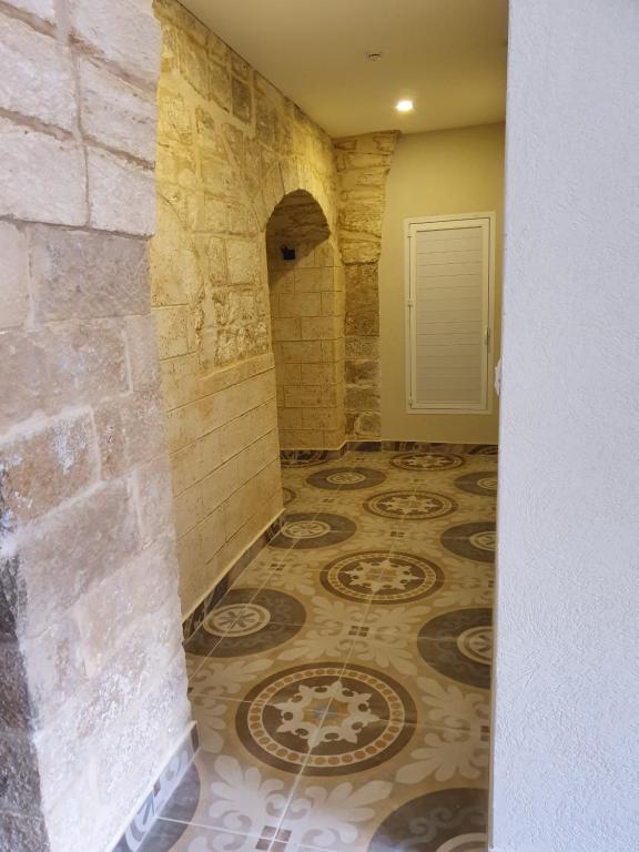 Habitación con pared de piedra y suelo de baldosa. en Angel's house, en Nazaret