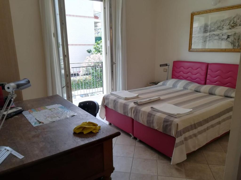 a bedroom with a bed and a desk and a window at Anania in Cagliari