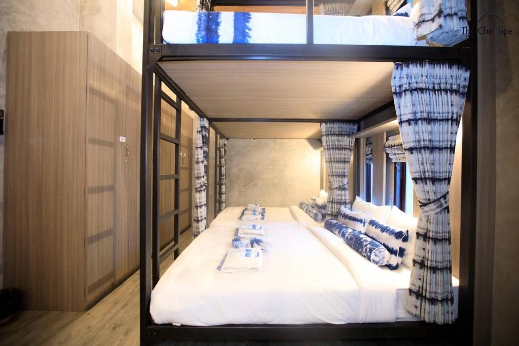 a room with two bunk beds with tables on them at The Chic Lipe in Ko Lipe