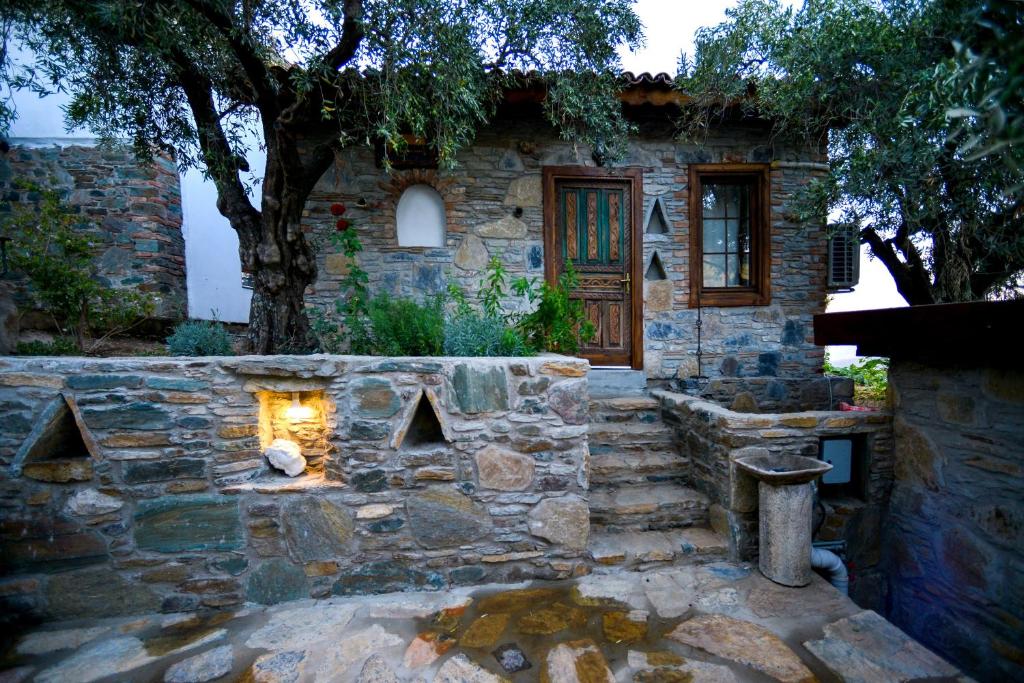 a stone house with a stone fireplace in front of it at Heaven's Gate in Sirince