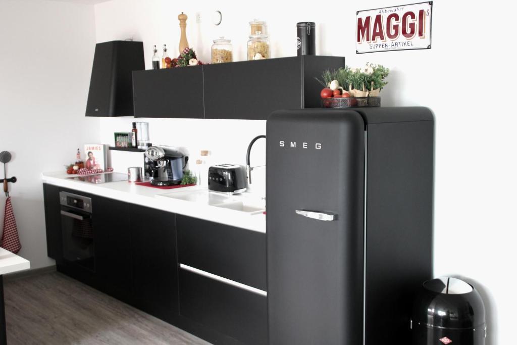 a black refrigerator in a kitchen next to a counter at REBENBLÄTTLE in Bad Dürkheim