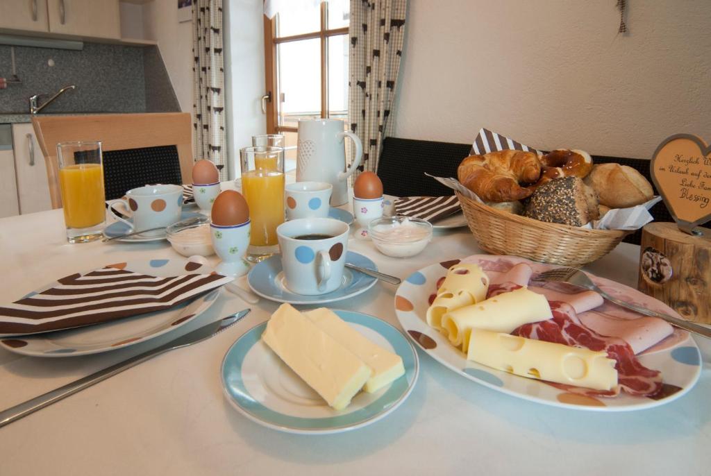 uma mesa coberta com pratos de queijo e ovos em Weißenbach´s Ferienhof em Wertach