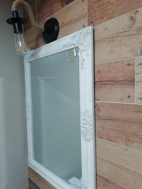 lustro przed drewnianą ścianą w obiekcie Casas Rurales Los Marqueses w mieście Valmuel