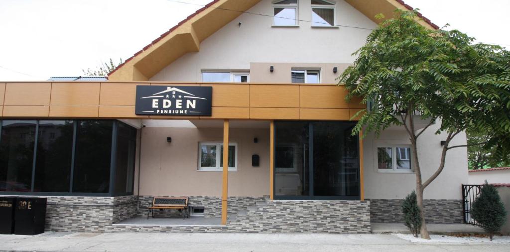 a building with a sign that reads edenulum at Pensiune EDEN in Slatina