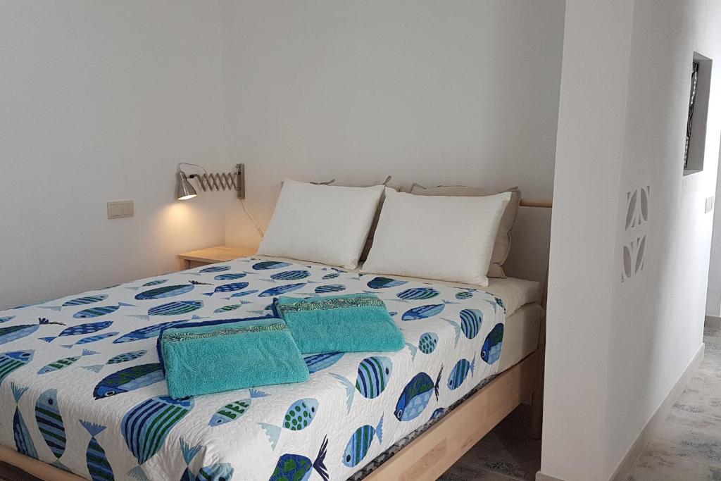 a bedroom with a bed with two pillows on it at Studio Azul in Olhão
