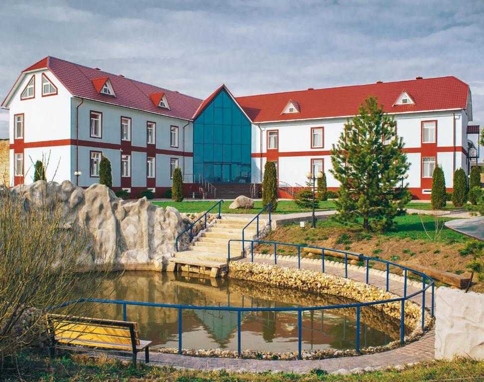 a building with a pond in front of a building at Hotel Amfora in Vyazma