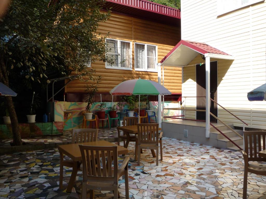 a patio with tables and chairs and an umbrella at Shanson in Gagra