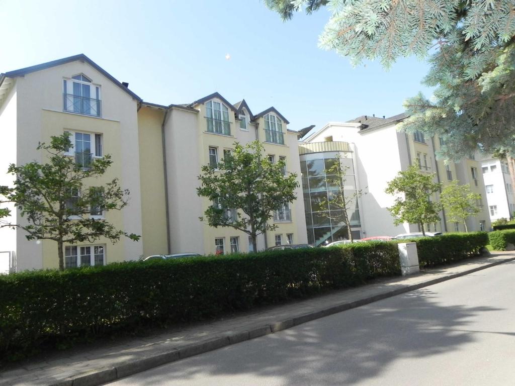 una fila de edificios de apartamentos blancos en una calle en Ferienwohnung 1_06 _Inselstrand_, en Ahlbeck