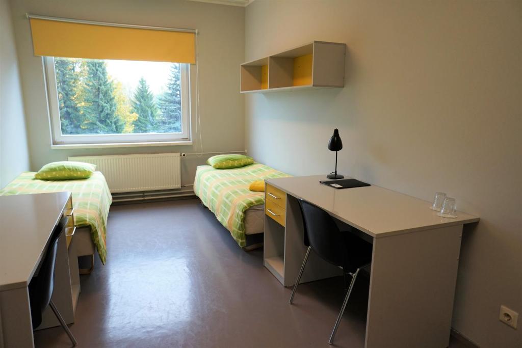 1 dormitorio con 2 camas, escritorio y ventana en Downtown Hostel en Tartu