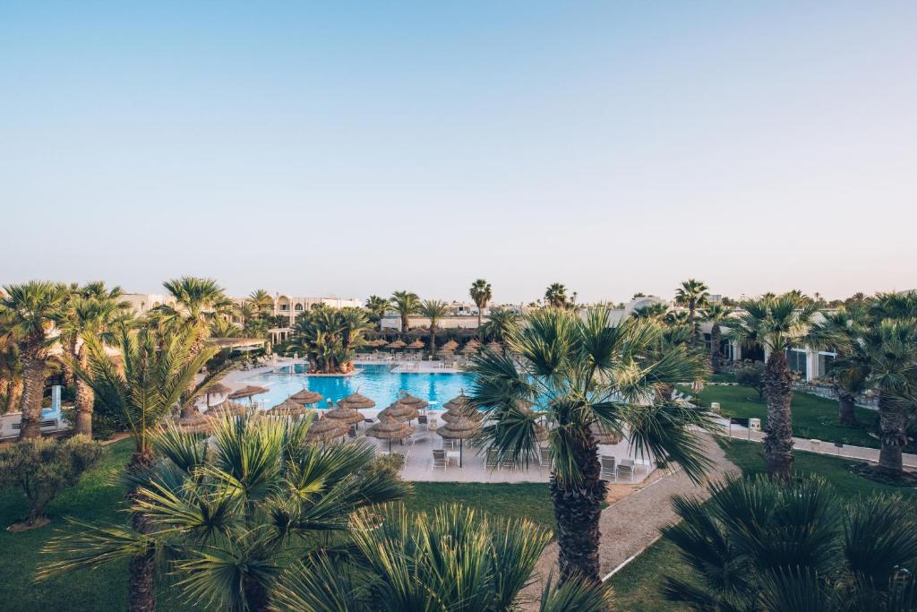 an aerial view of a resort pool with palm trees at Iberostar Waves Mehari Djerba in Taguermess