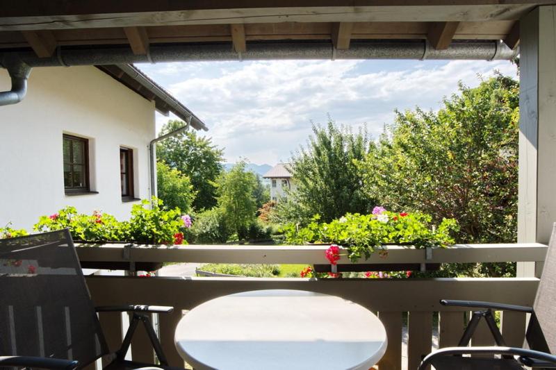 eine Terrasse mit einem Tisch, Stühlen und Blumen in der Unterkunft Ferienwohnung Behrens in Bad Hindelang
