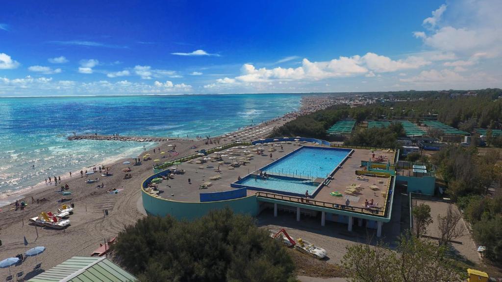 einen Swimmingpool am Strand neben dem Meer in der Unterkunft Happy Camp Mobile Homes in Camping Village Rosapineta in Rosolina Mare