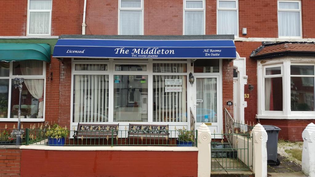 una tienda con una señal azul delante de un edificio en The Middleton, en Blackpool