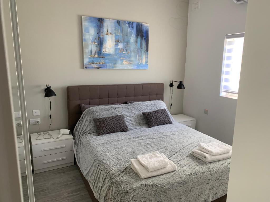 una camera da letto con un letto e due asciugamani di St Julians Apartment 2 a San Giuliano