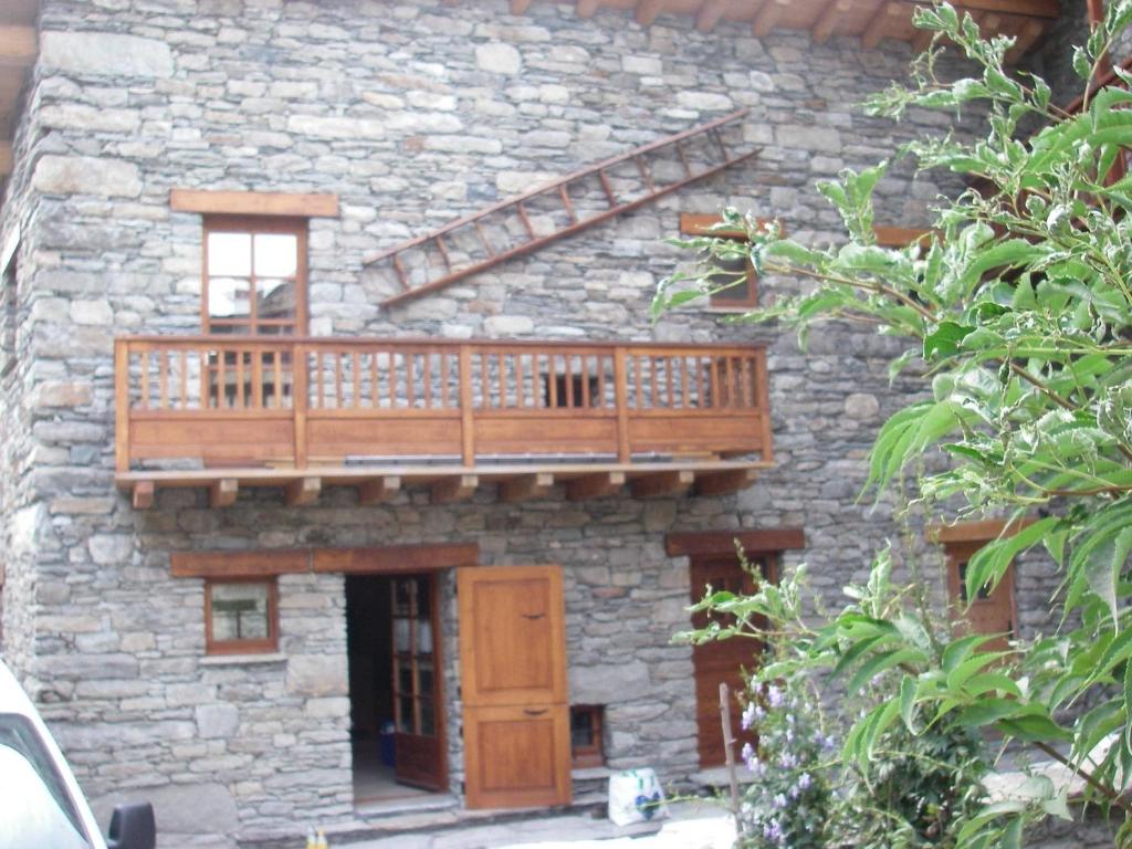 a deck on the side of a stone building at La Centaurée in Bonneval-sur-Arc