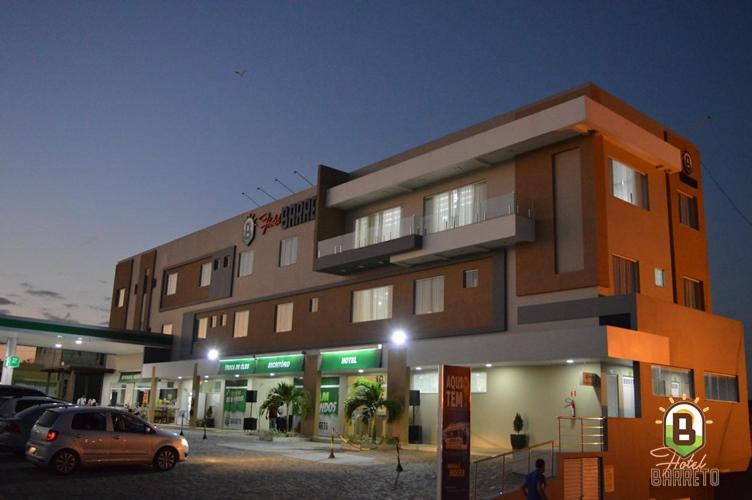 a building with a car parked in front of it at Hotel Barreto in Nossa Senhora da Glória