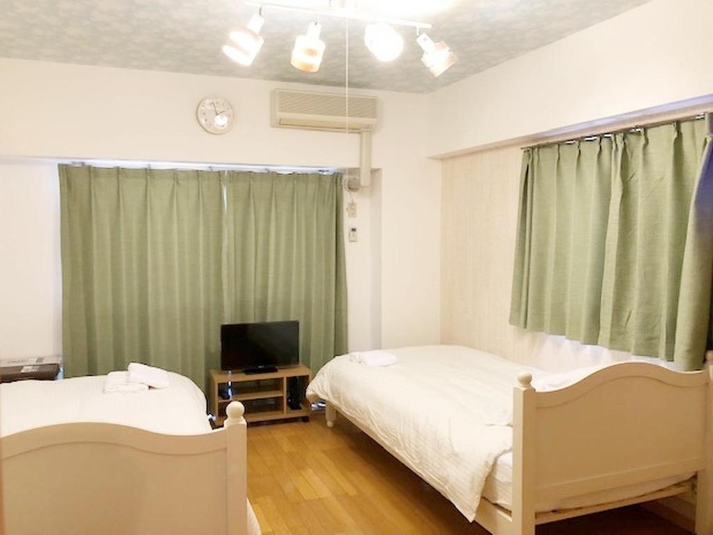 Susakiuramachiにあるピオーレ大手門501のベッドルーム(ベッド2台、テレビ付)